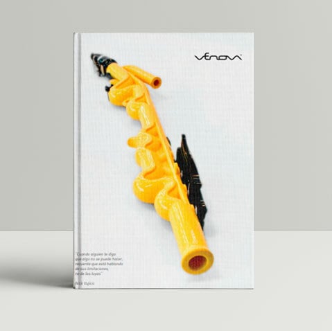 instrumento musical, que parece un tipo de flauta o clarinete, ocupa la mayor parte del espacio de la portada. Es de color amarillo intenso, con algunos componentes de color negro. Su diseño es orgánico y ligeramente curvilíneo, no completamente simétrico. Se asemeja a un instrumento plástico o de juguete, aunque su apariencia sugiere un diseño intencional y no simplemente un juguete infantil.
