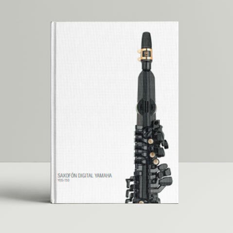 instrumento musical, que parece un tipo de flauta o clarinete, ocupa la mayor parte del espacio de la portada. Es de color Negro, Su diseño es orgánico y ligeramente curvilíneo, no completamente simétrico. Se asemeja a un instrumento plástico o de juguete, aunque su apariencia sugiere un diseño intencional y no simplemente un juguete infantil.